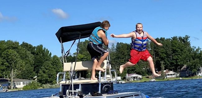 young boy jumping from boat into water at Gateway Park Campground in MI Top 5 Reasons Gateway Park Campground is Perfect for Families