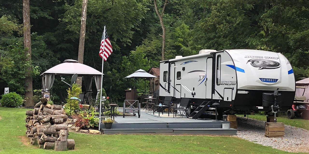 Seasonal RV site with patio and wooded surroundings at Gateway Park Campground