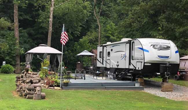 gateway-park-seasonal-rv-site-spring-camping Seasonal RV site with patio and wooded surroundings at Gateway Park Campground